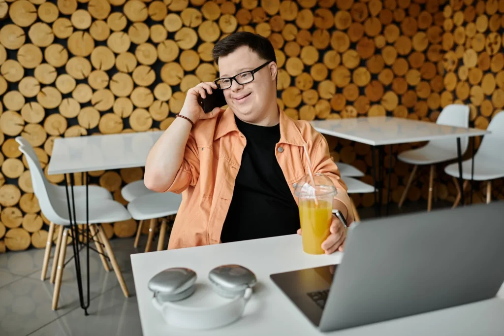 Disabled man with down syndrome making phone call to contact Red Rose Support Services