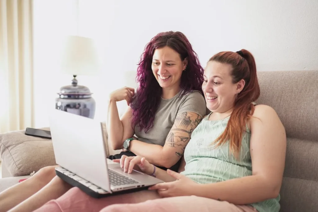 Two friends looking at laptop to make NDIS referral