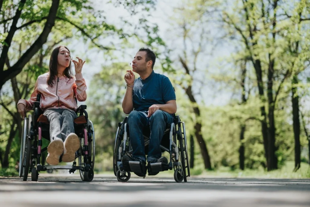 Two disabled friends in park blowing bubbles